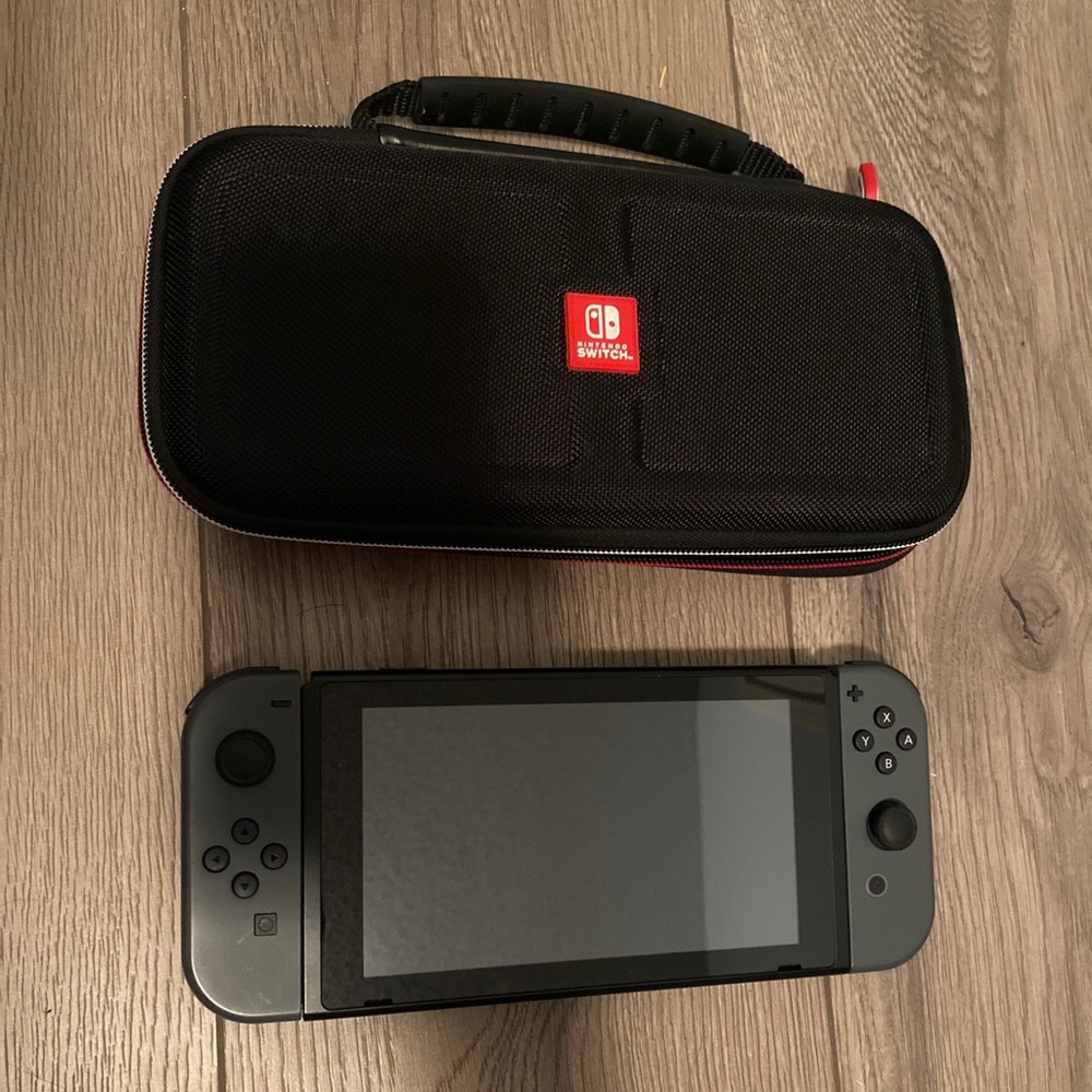 grey nintendo switch with charger and case